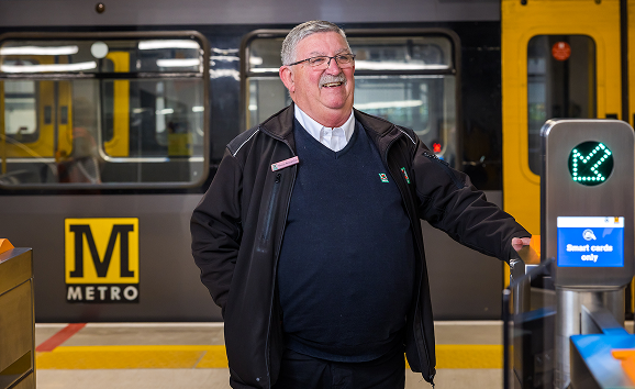 A Metro employee in uniform standing in front of a Metro