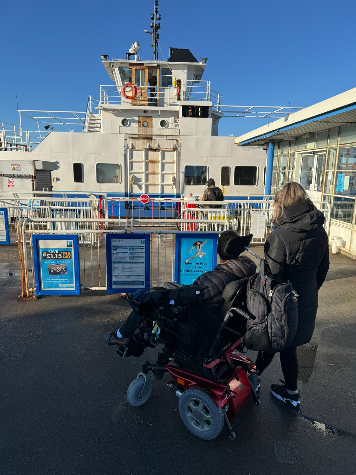 A man in a wheelchair and a woman on the ferry landing