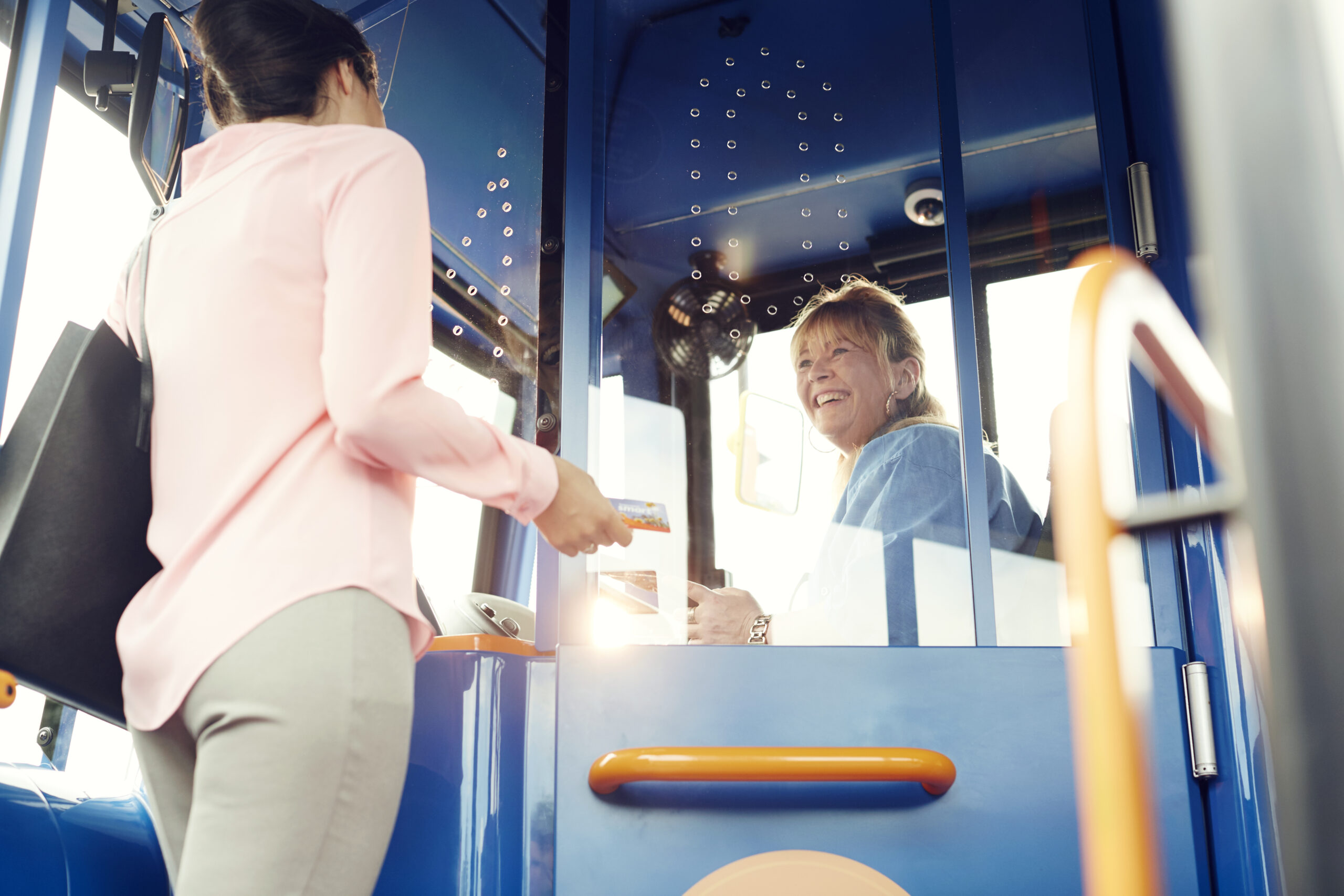 A customer boarding a bus and paying the driver