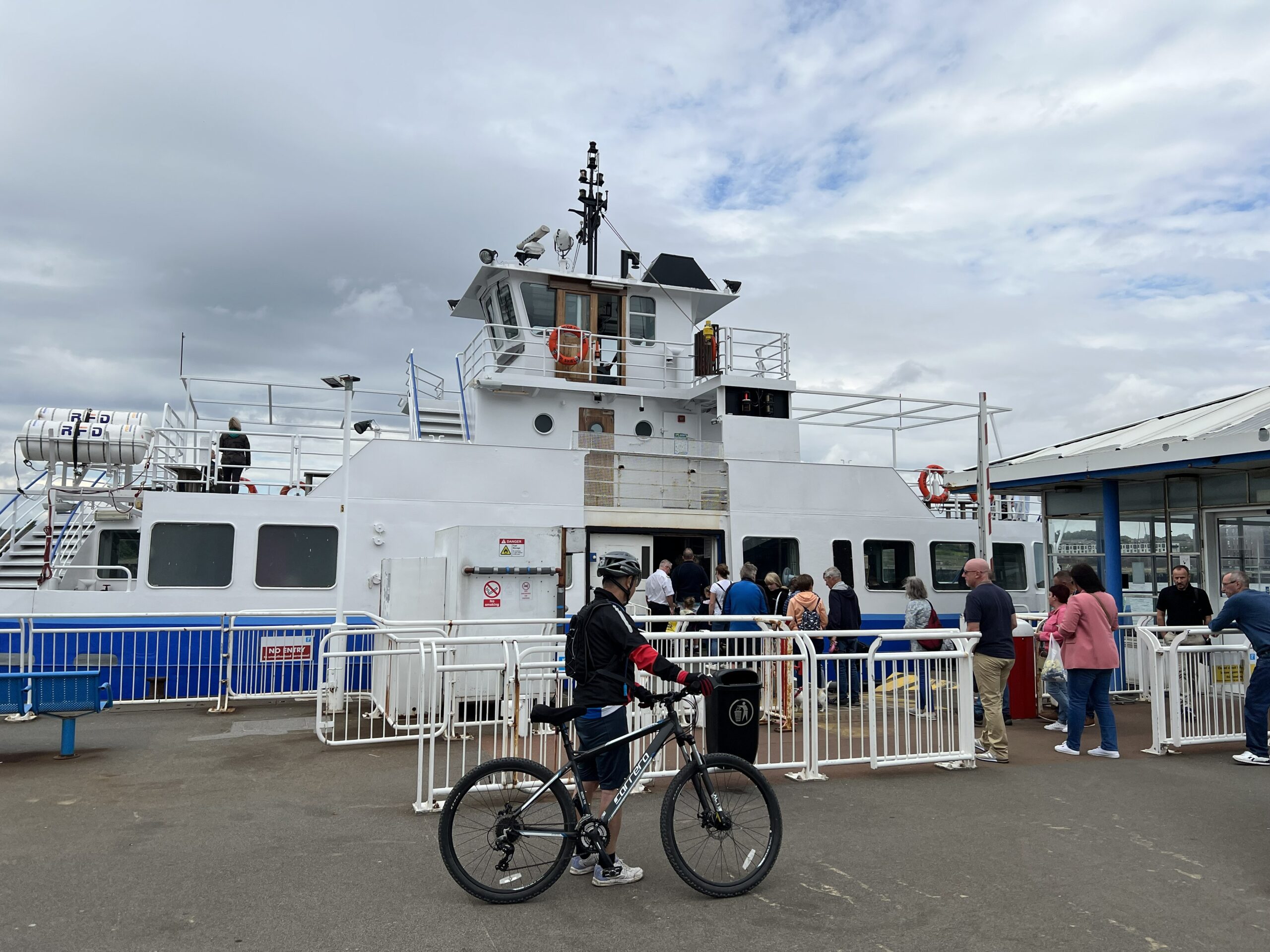 A cyclist and other customers wait to board the Shields Ferry