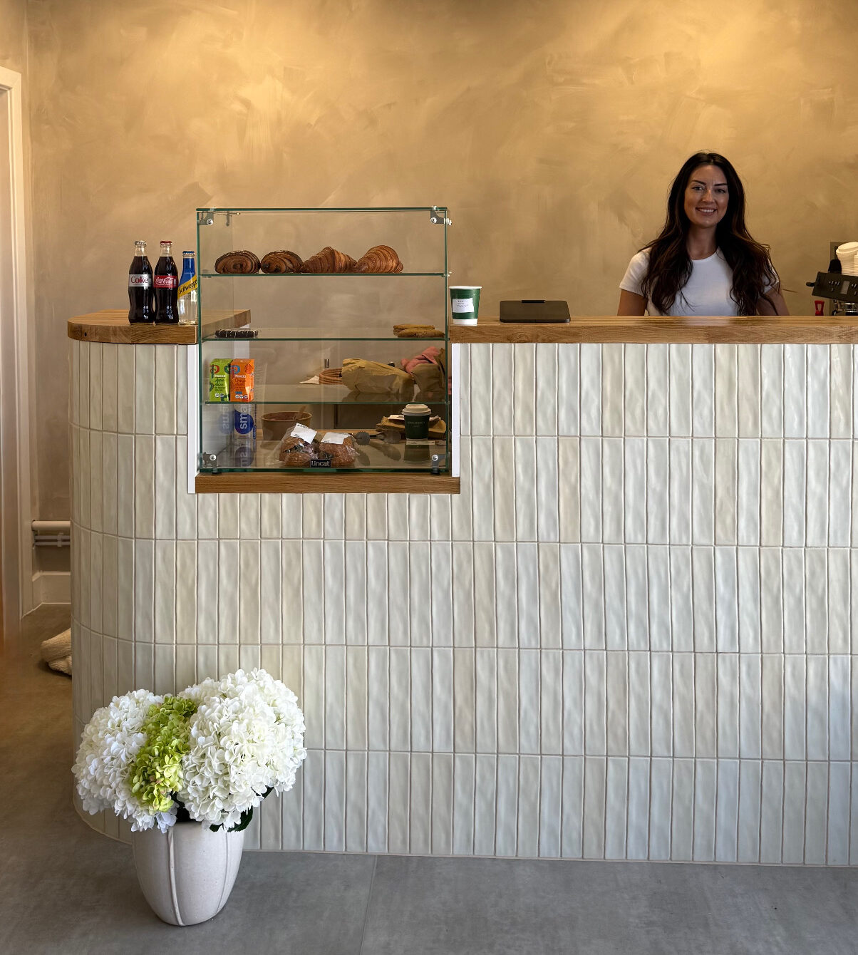 A lady standing behind a counter in a coffee shop